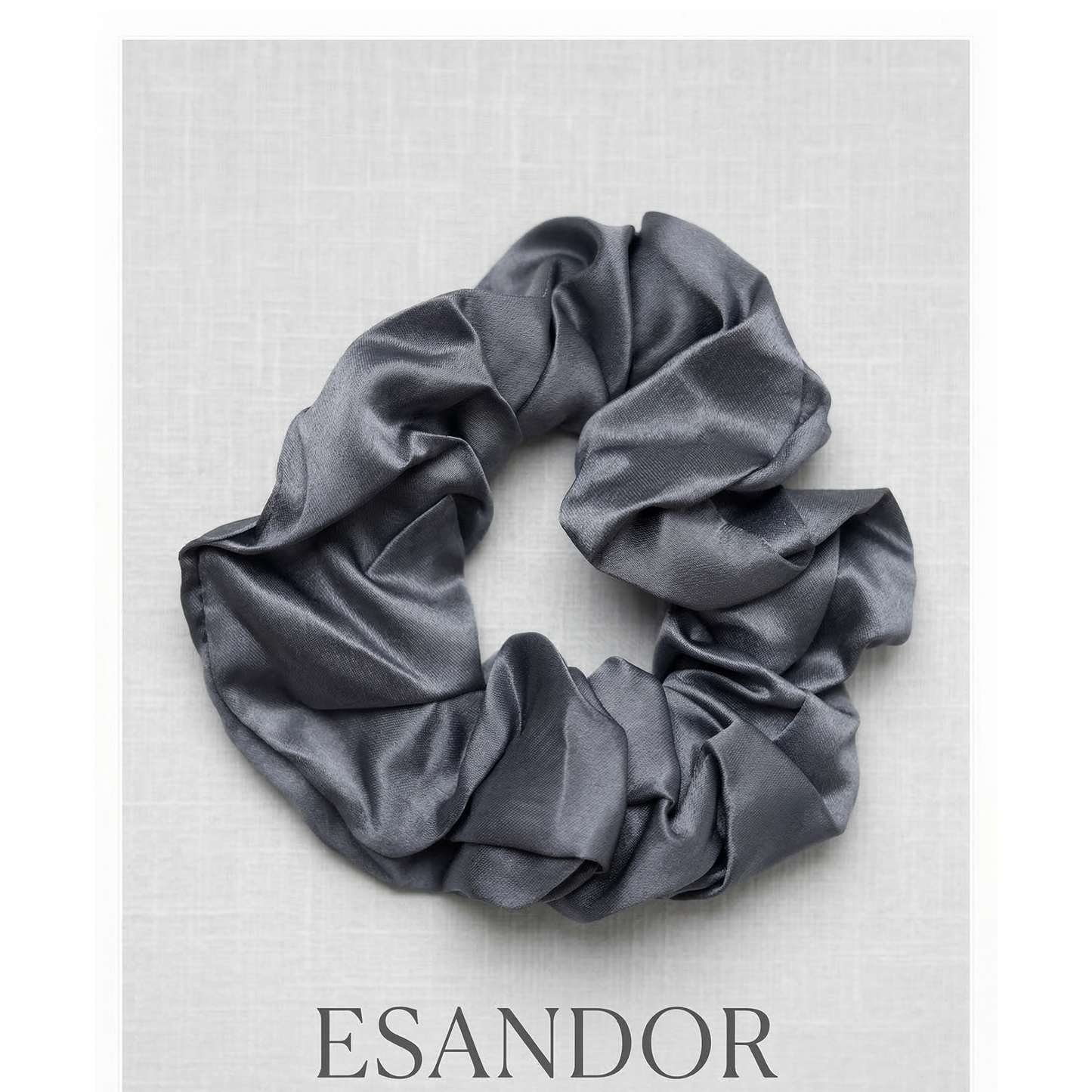 Gray satin scrunchie on a light gray background with 'ESANDOR' branding.