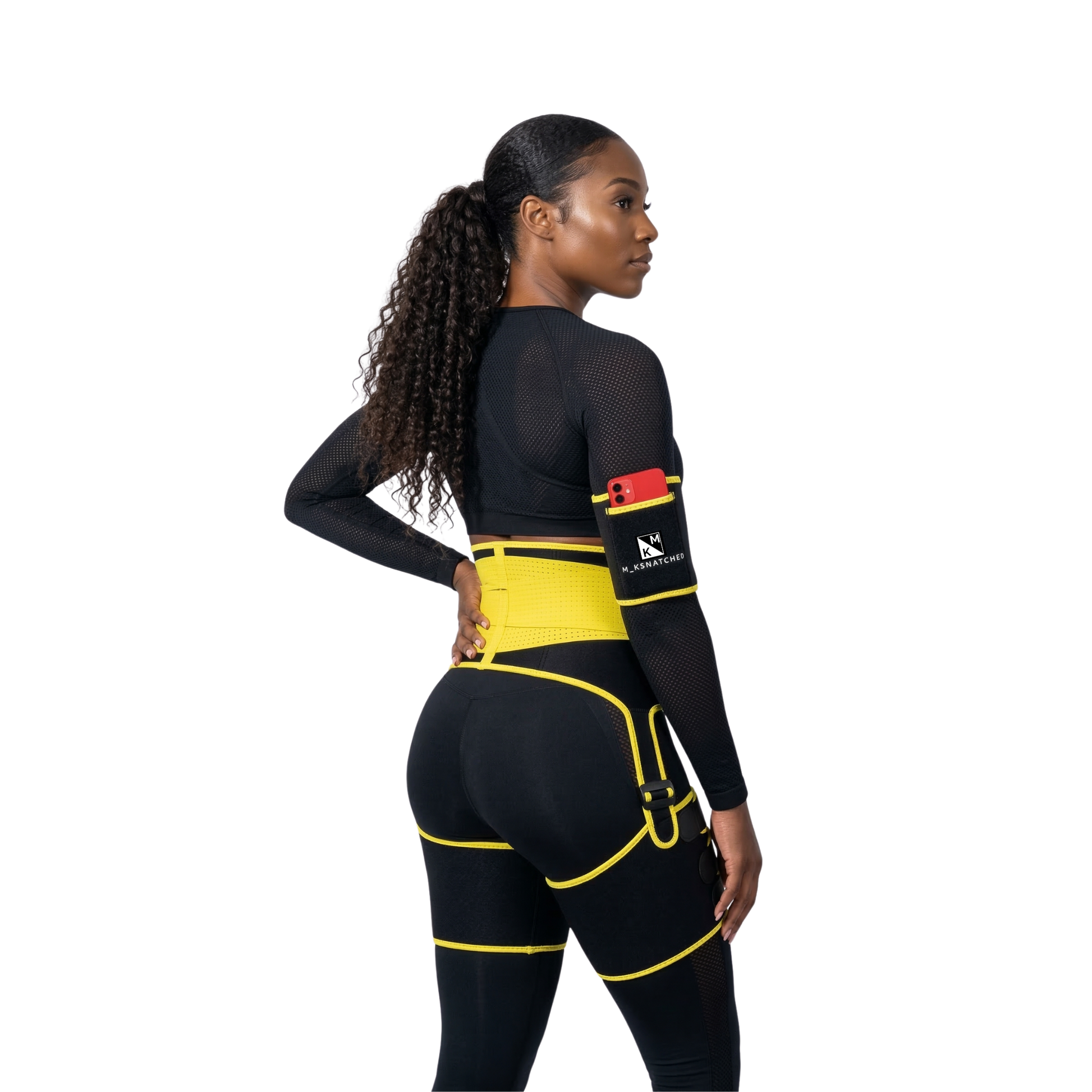 Woman wearing a black and yellow athletic outfit with a visible brand logo on a white background