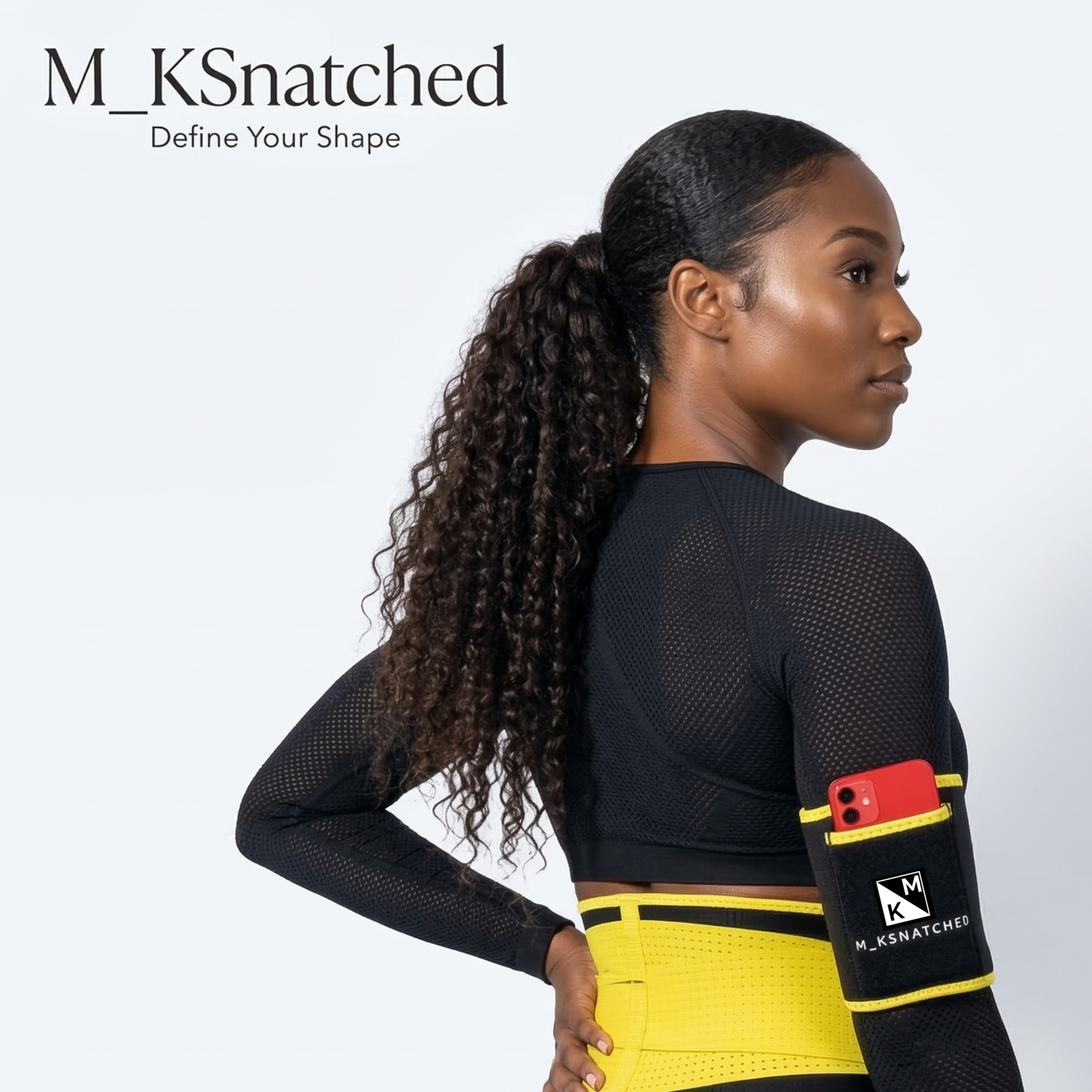 Woman wearing a black and yellow athletic outfit with a phone pocket, branded 'M_KSnatched'.