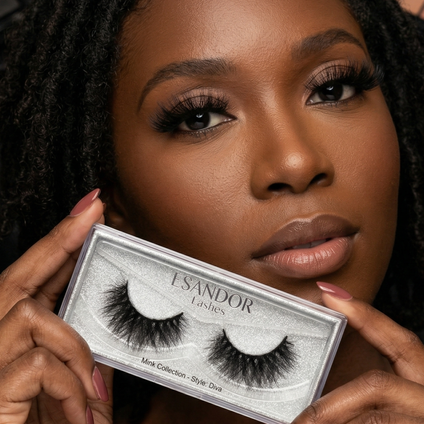 Woman holding a box of ESANDOR lashes with a close-up of the packaging.