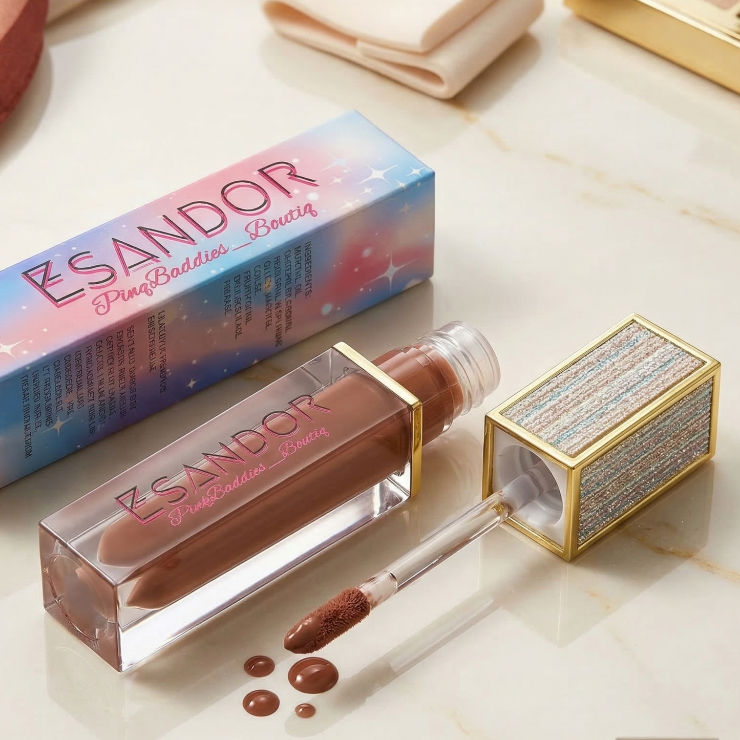 Lip gloss with applicator and packaging on a light surface