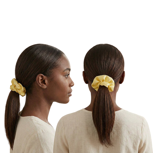 Woman with a yellow scrunchie in her ponytail on a white background