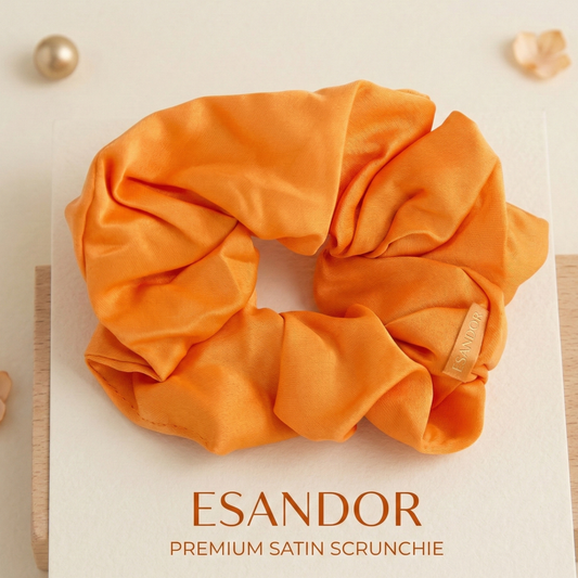 Orange satin scrunchie with 'ESANDOR' branding on a light background
