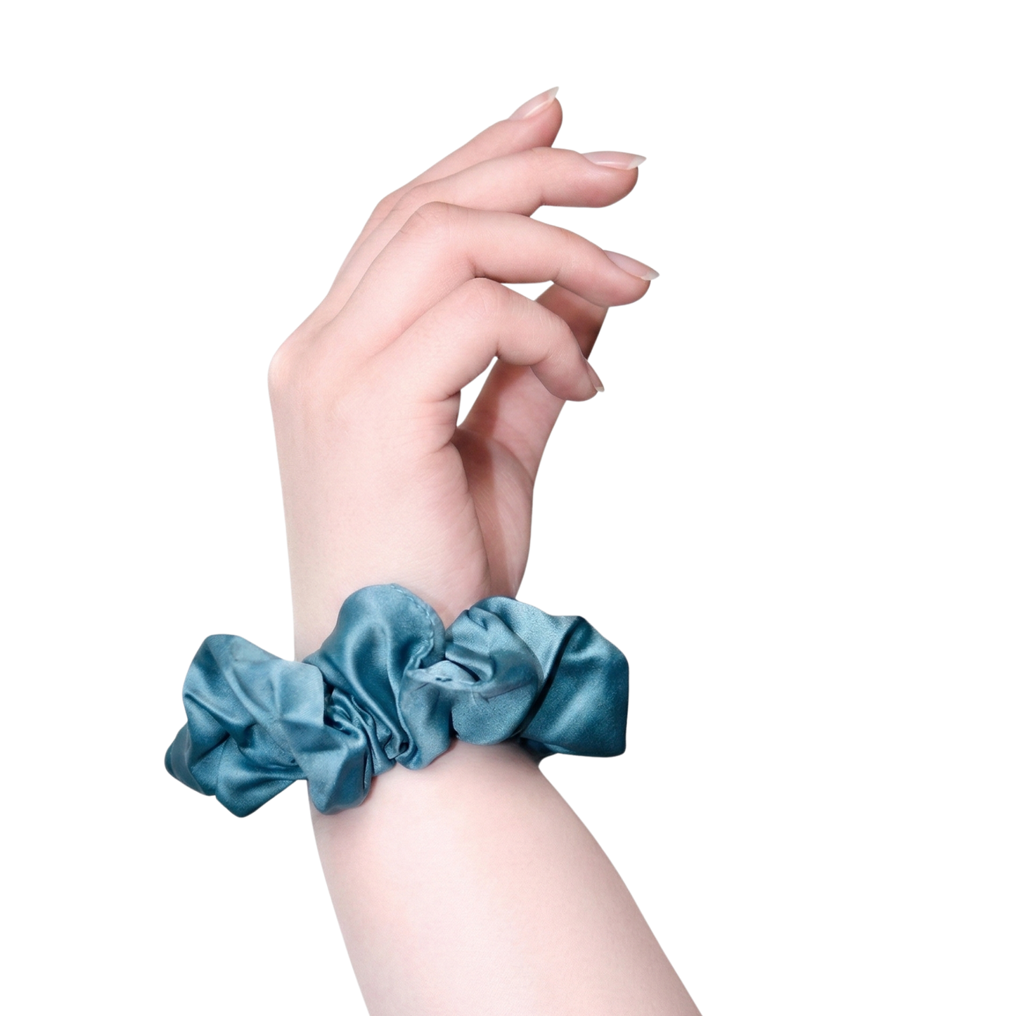 Hand wearing a blue satin scrunchie on a white background