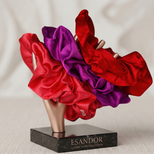 Red and purple satin hair scrunchies on a black marble stand with 'ESANDOR' branding.