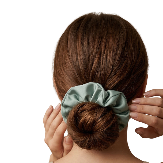 Person with a bun holding a green scrunchie against a white background