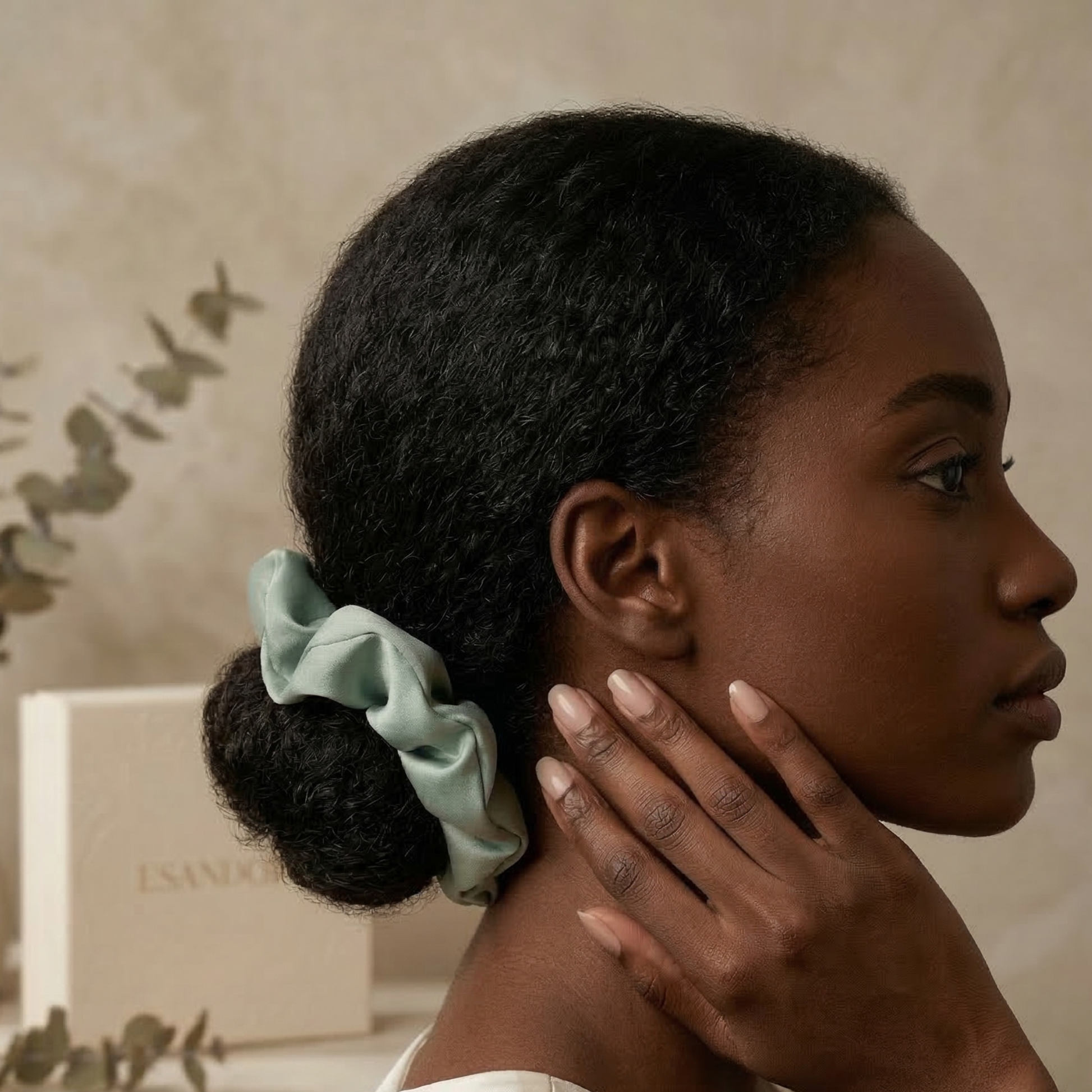 Woman with a scrunchie in her hair, with a neutral background